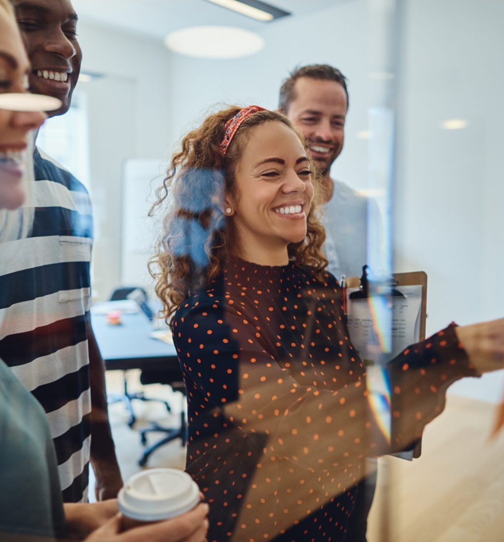 Smiling designers brainstorming together with notes in an office long term care software